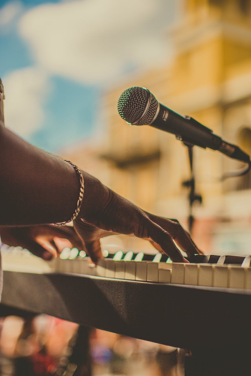Manos tocando el teclado de un piano durante rodaje musical al aire libre